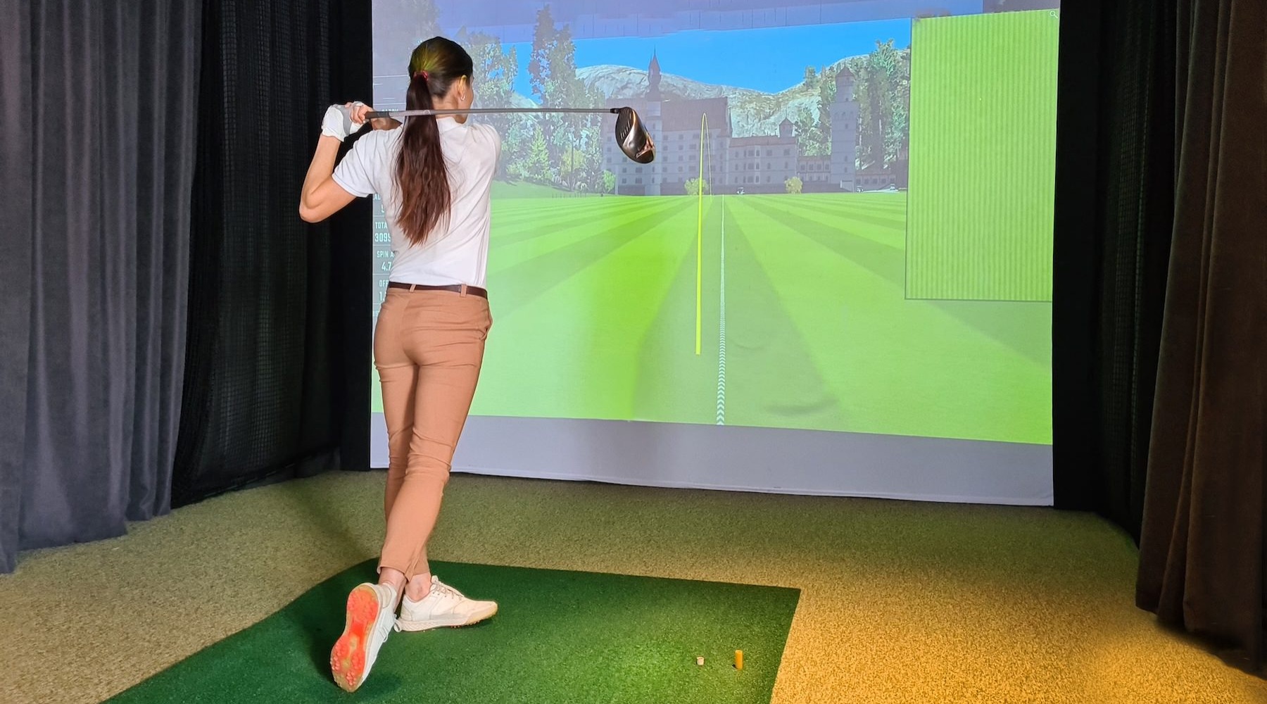 a woman using a golf simulator